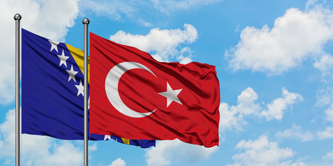 Bosnia Herzegovina and Turkey flag waving in the wind against white cloudy blue sky together. Diplomacy concept, international relations.