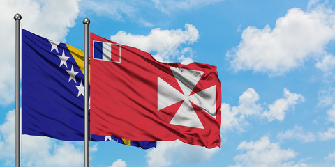 Bosnia Herzegovina and Wallis And Futuna flag waving in the wind against white cloudy blue sky together. Diplomacy concept, international relations.