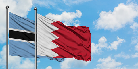 Botswana and Bahrain flag waving in the wind against white cloudy blue sky together. Diplomacy concept, international relations.