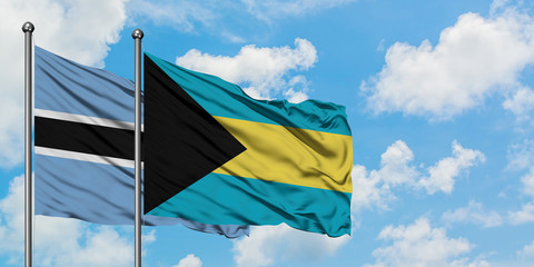 Botswana and Bahamas flag waving in the wind against white cloudy blue sky together. Diplomacy concept, international relations.