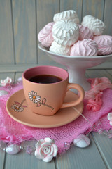 Still life with cup of black coffee and vintage marshmallow on pastel blue wooden background. Wedding or Valentine day concept