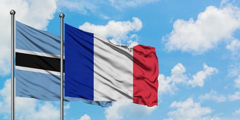 Botswana and France flag waving in the wind against white cloudy blue sky together. Diplomacy concept, international relations.