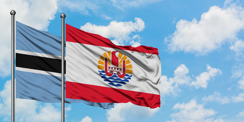 Botswana and French Polynesia flag waving in the wind against white cloudy blue sky together. Diplomacy concept, international relations.