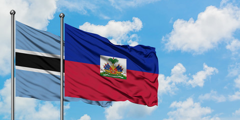 Botswana and Haiti flag waving in the wind against white cloudy blue sky together. Diplomacy concept, international relations.