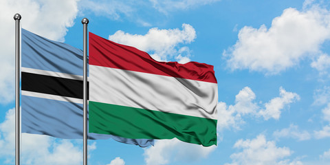 Botswana and Hungary flag waving in the wind against white cloudy blue sky together. Diplomacy concept, international relations.