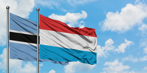 Botswana and Luxembourg flag waving in the wind against white cloudy blue sky together. Diplomacy concept, international relations.
