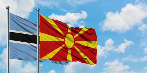 Botswana and Macedonia flag waving in the wind against white cloudy blue sky together. Diplomacy concept, international relations.