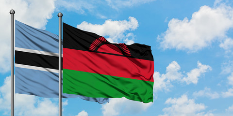 Botswana and Malawi flag waving in the wind against white cloudy blue sky together. Diplomacy concept, international relations.