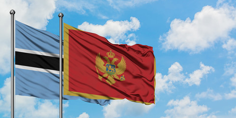 Botswana and Montenegro flag waving in the wind against white cloudy blue sky together. Diplomacy concept, international relations.