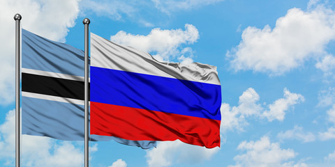 Botswana and Russia flag waving in the wind against white cloudy blue sky together. Diplomacy concept, international relations.