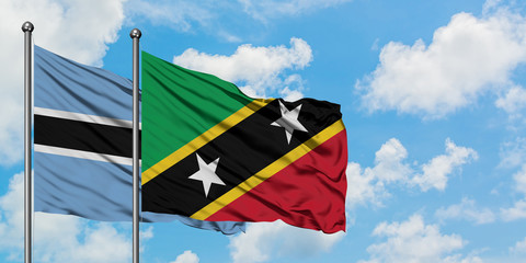 Botswana and Saint Kitts And Nevis flag waving in the wind against white cloudy blue sky together. Diplomacy concept, international relations.