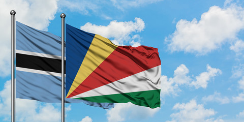 Botswana and Seychelles flag waving in the wind against white cloudy blue sky together. Diplomacy concept, international relations.