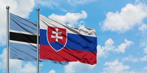 Botswana and Slovakia flag waving in the wind against white cloudy blue sky together. Diplomacy concept, international relations.