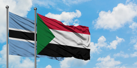 Botswana and Sudan flag waving in the wind against white cloudy blue sky together. Diplomacy concept, international relations.