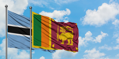 Botswana and Sri Lanka flag waving in the wind against white cloudy blue sky together. Diplomacy...