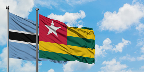 Botswana and Togo flag waving in the wind against white cloudy blue sky together. Diplomacy concept, international relations.