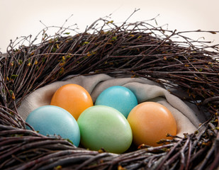 Multicolored eggs in a nest.