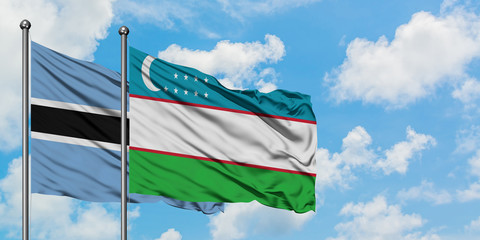Botswana and Uzbekistan flag waving in the wind against white cloudy blue sky together. Diplomacy concept, international relations.