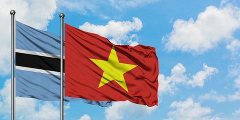 Botswana and Vietnam flag waving in the wind against white cloudy blue sky together. Diplomacy concept, international relations.