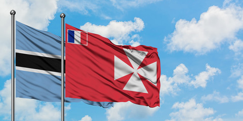 Botswana and Wallis And Futuna flag waving in the wind against white cloudy blue sky together. Diplomacy concept, international relations.