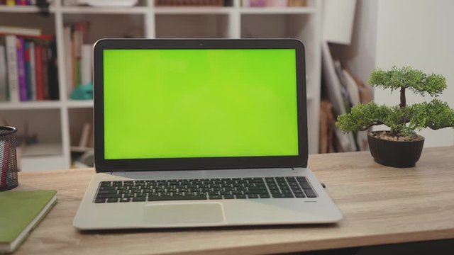 Close up laptop computer with green screen chroma key display internet business office technology work desk connection keyboard pc device using slow motion