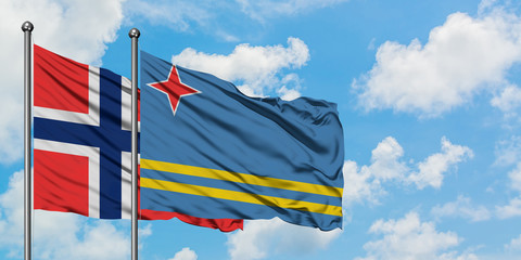 Bouvet Islands and Aruba flag waving in the wind against white cloudy blue sky together. Diplomacy concept, international relations.