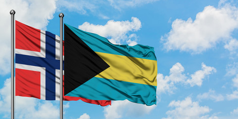 Bouvet Islands and Bahamas flag waving in the wind against white cloudy blue sky together. Diplomacy concept, international relations.