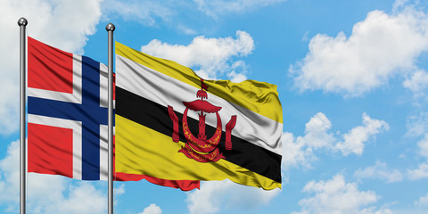 Bouvet Islands and Brunei flag waving in the wind against white cloudy blue sky together. Diplomacy concept, international relations.