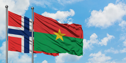 Bouvet Islands and Burkina Faso flag waving in the wind against white cloudy blue sky together. Diplomacy concept, international relations.