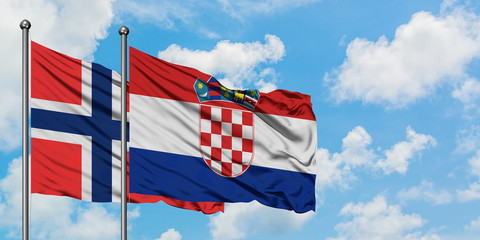 Bouvet Islands and Croatia flag waving in the wind against white cloudy blue sky together....