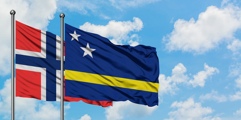 Bouvet Islands and Curacao flag waving in the wind against white cloudy blue sky together. Diplomacy concept, international relations.