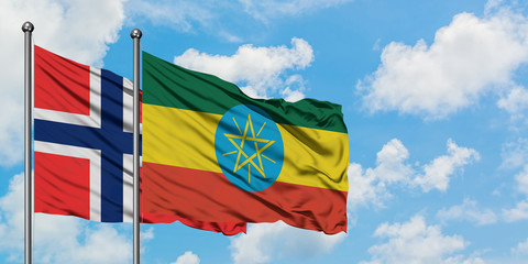 Bouvet Islands and Ethiopia flag waving in the wind against white cloudy blue sky together. Diplomacy concept, international relations.