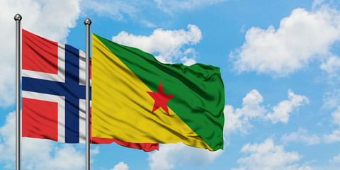 Bouvet Islands and French Guiana flag waving in the wind against white cloudy blue sky together. Diplomacy concept, international relations.