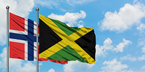 Bouvet Islands and Jamaica flag waving in the wind against white cloudy blue sky together. Diplomacy concept, international relations.