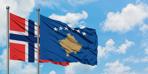 Bouvet Islands and Kosovo flag waving in the wind against white cloudy blue sky together. Diplomacy concept, international relations.