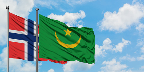 Bouvet Islands and Mauritania flag waving in the wind against white cloudy blue sky together. Diplomacy concept, international relations.