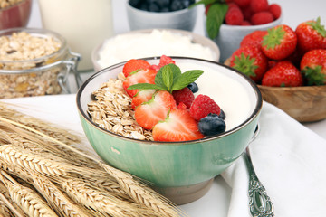Tasty homemade granola served on table. Healthy breakfast with a bowl of oatmeal with banana, blueberries, strawberries and healthy food for Breakfast
