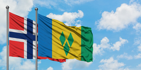 Bouvet Islands and Saint Vincent And The Grenadines flag waving in the wind against white cloudy...