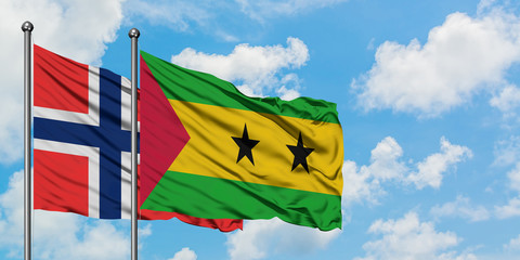 Bouvet Islands and Sao Tome And Principe flag waving in the wind against white cloudy blue sky together. Diplomacy concept, international relations.