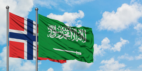 Bouvet Islands and Saudi Arabia flag waving in the wind against white cloudy blue sky together. Diplomacy concept, international relations.