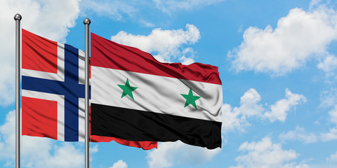 Bouvet Islands and Syria flag waving in the wind against white cloudy blue sky together. Diplomacy concept, international relations.