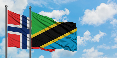 Bouvet Islands and Tanzania flag waving in the wind against white cloudy blue sky together. Diplomacy concept, international relations.