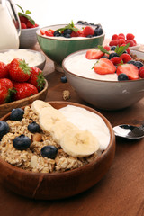 Tasty homemade granola served on table. Healthy breakfast with a bowl of oatmeal with banana, blueberries, strawberries and healthy food for Breakfast