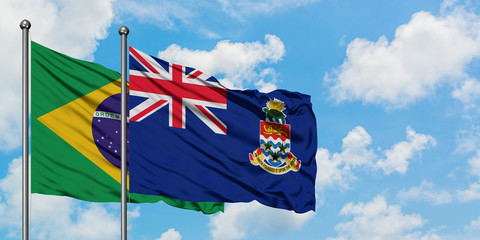 Brazil and Cayman Islands flag waving in the wind against white cloudy blue sky together. Diplomacy concept, international relations.