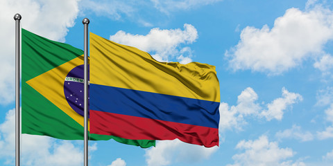 Brazil and Colombia flag waving in the wind against white cloudy blue sky together. Diplomacy concept, international relations.