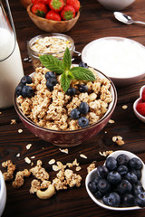 Tasty homemade granola served on table. Healthy breakfast with a bowl of oatmeal with banana, blueberries, strawberries and healthy food for Breakfast