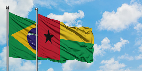 Brazil and Guinea Bissau flag waving in the wind against white cloudy blue sky together. Diplomacy concept, international relations.