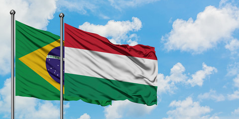 Brazil and Hungary flag waving in the wind against white cloudy blue sky together. Diplomacy concept, international relations.