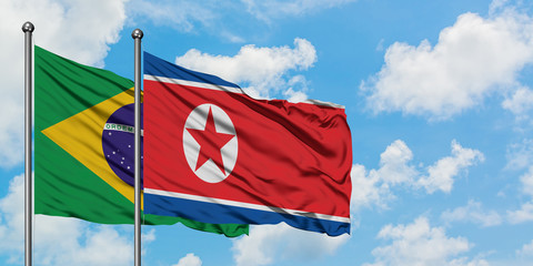 Brazil and North Korea flag waving in the wind against white cloudy blue sky together. Diplomacy concept, international relations.