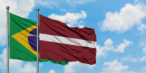 Brazil and Latvia flag waving in the wind against white cloudy blue sky together. Diplomacy concept, international relations.